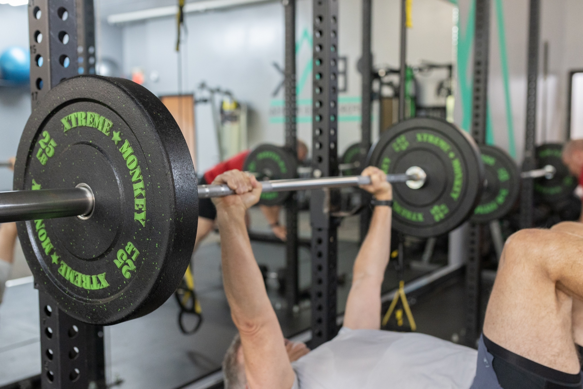 Client pressing a barbell during a bench session